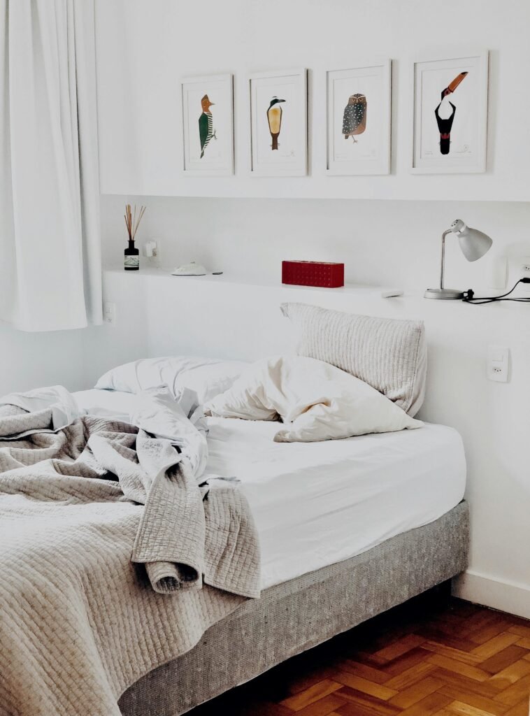 Home 1 Contemporary bedroom design featuring art prints and cozy bedding for a warm ambiance.