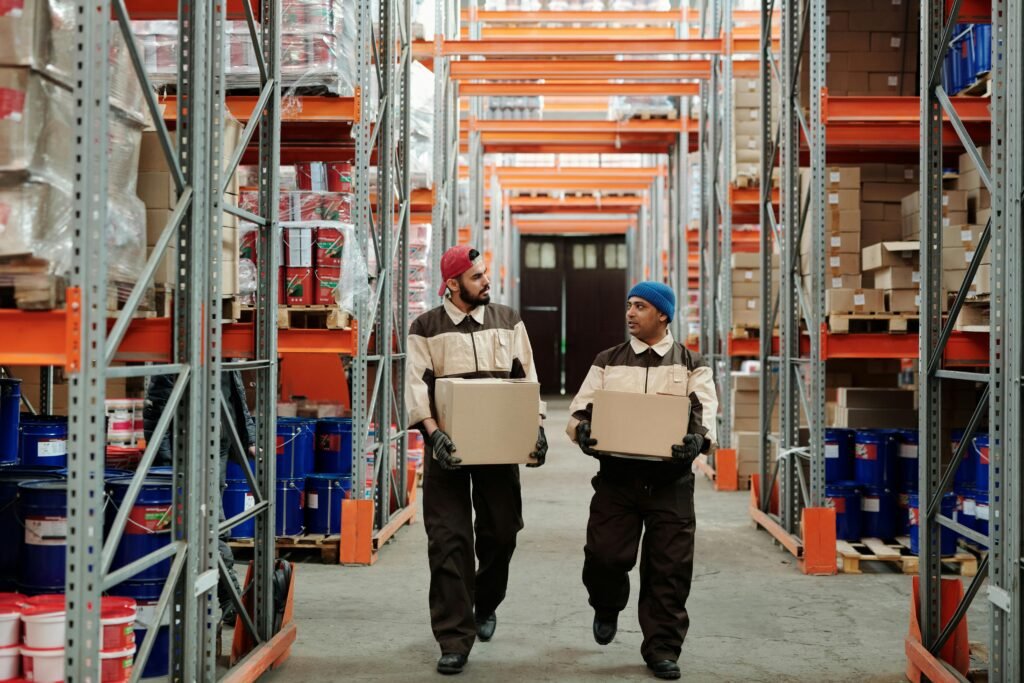 How To Stay Energized on Night Shifts: A Science-Backed Guide 8 Two workers carrying boxes in a warehouse aisle, engaged in logistics