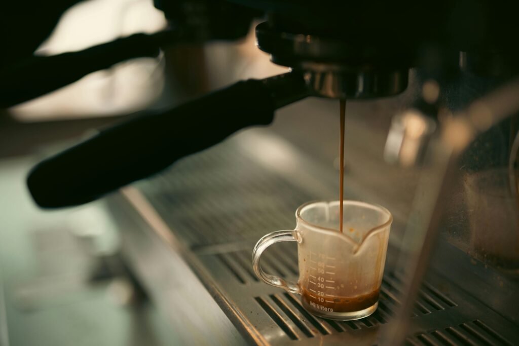 What to Do When Night Shift Insomnia Won't Go Away: Breaking the Cycle 6 Espresso pouring into a measuring cup from a coffee machine, warm tones.