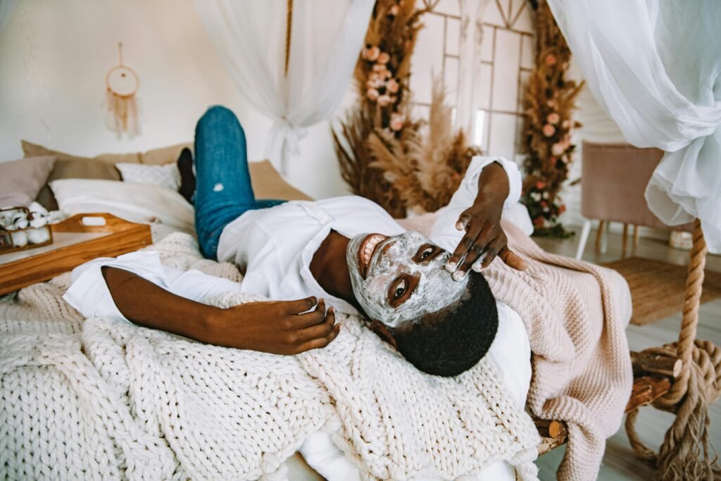 How to Combat Night Shift Skin Problems 1 Woman enjoying a self-care day at home with a face mask, relaxing on her cozy bed.