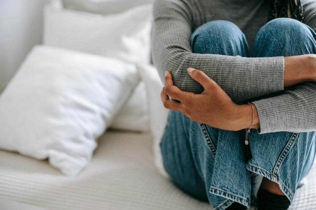 How to Combat Night Shift Skin Problems 5 Crop faceless female feeling helpless and frustrated embracing knees while sitting on bed in loneliness