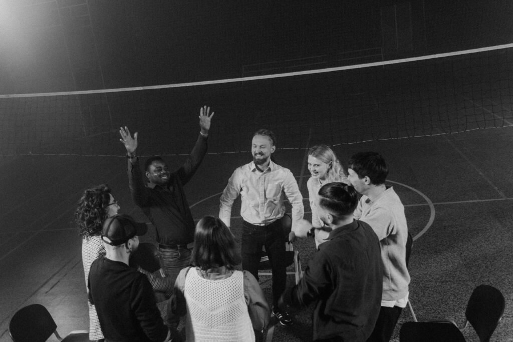 What to Do About Night Shift Depression: Recognition and Self-Care Steps 5 A diverse group of people in a team building huddle indoors, fostering togetherness and support.