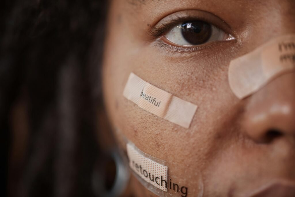 How to Combat Night Shift Skin Problems 2 Close-up of a woman's face with band-aids featuring text, reflecting beauty and self-image themes.