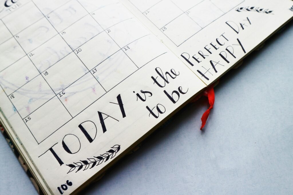 What to Do About Night Shift Depression: Recognition and Self-Care Steps 9 Open planner with handwritten quotes and calendar layout, promoting positivity and organization.