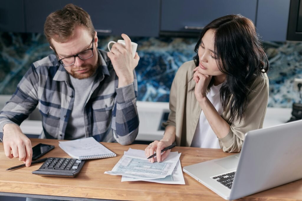 Night Shift and Relationships: Communication Solutions That Work 4 A couple reviews bills and documents on a laptop while discussing household finances.