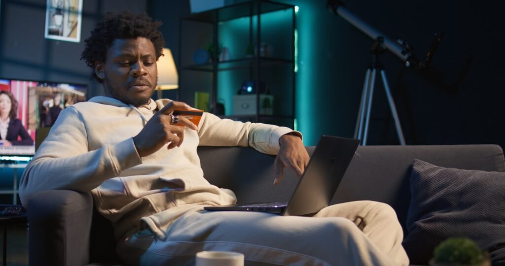 smiling african american man entering card digits confirm money transfer 1