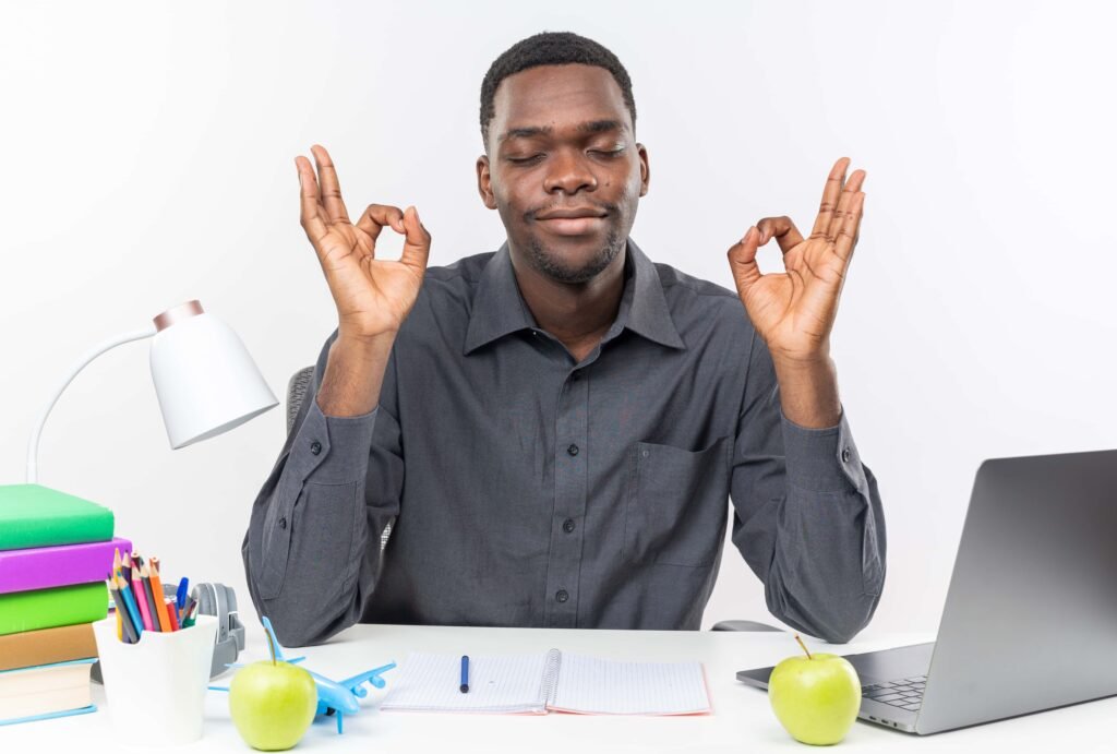 The Night Shift Advantage: Surprising Benefits No One Talks About 7 pleased young afro american student sitting with closed eyes desk with school tools meditating isolated white wall 1