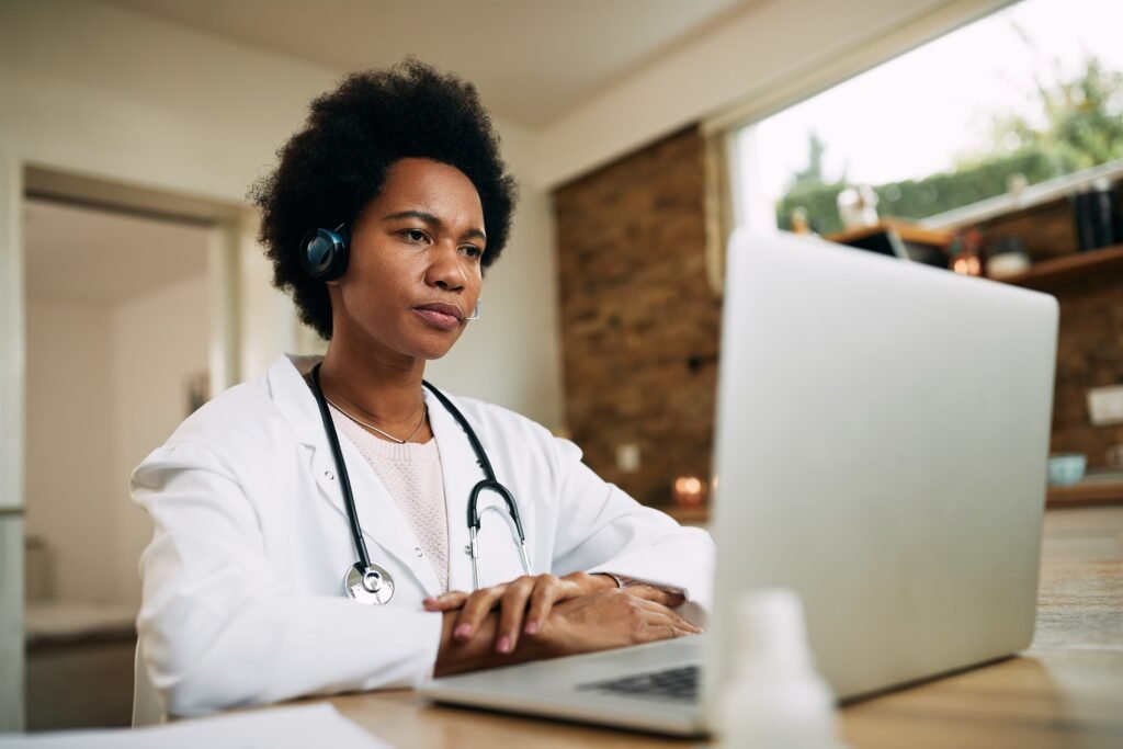 black female doctor having conference call laptop 1