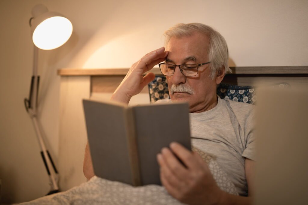 Does Night Shift Make You Age Faster? What the Science Actually Says 4 senior man reading book while lying down bed evening 1
