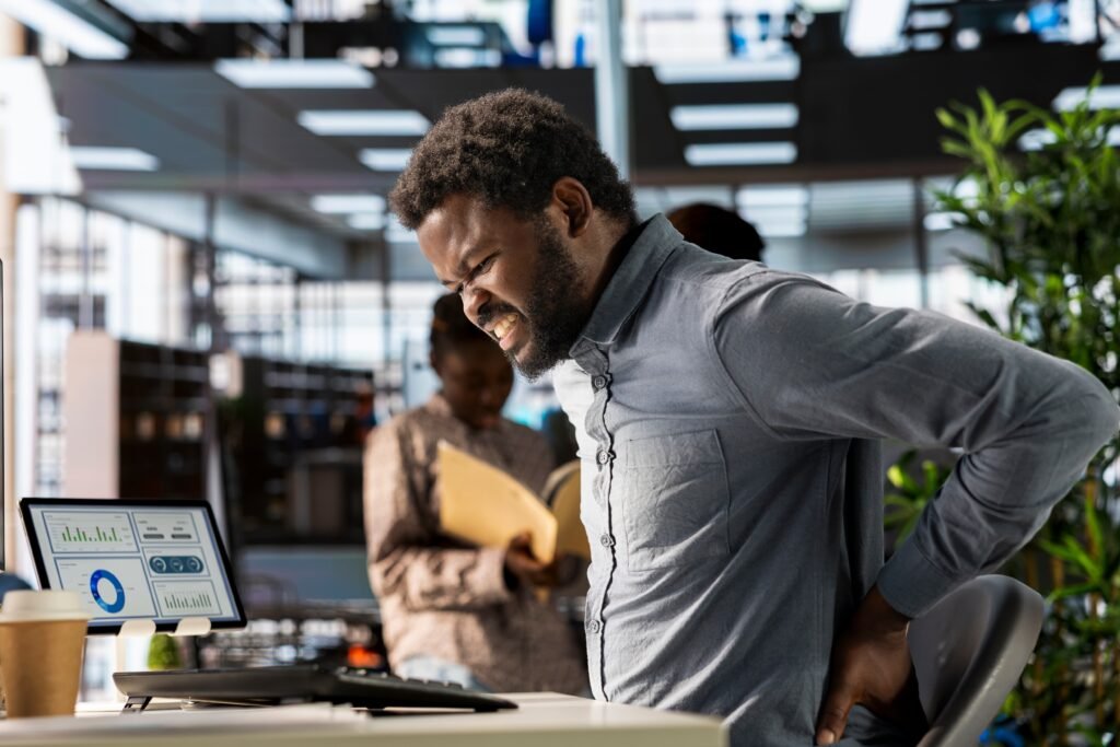 Night Shift and Back Pain: Why Your Spine Suffers on Overnights and How to Protect It 2 african american business analyst deals with back pain muscle cramps 1