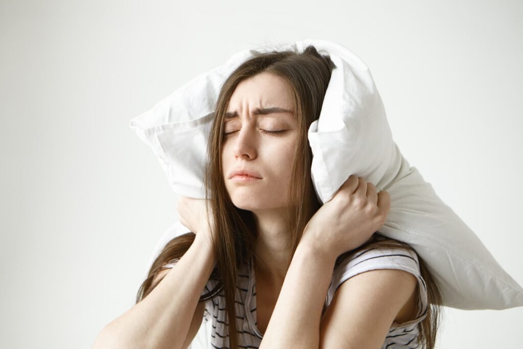 How to Stay Awake on Night Shift: The Science-Backed Guide to Beating Overnight Fatigue 2 pretty student woman striped t shirt trying have some sleep sitting bedroom with pillow her head closing eyes 1